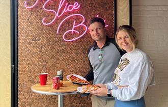 A couple eating pizza at Slice Bros