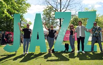 People stood next to big JAZZ sign.