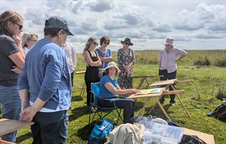 People watching an art demonstration on Cleeve Hill