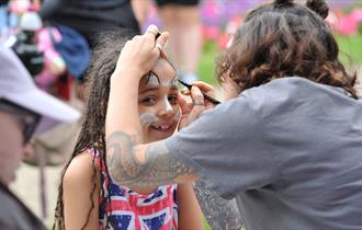 A child having her face painted.