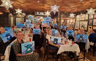 Group of ladies showing their cow paintings