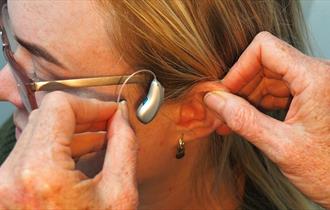 Woman receiving a hearing aid