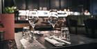A set dining table at Brasserie Blanc Cheltenham, with two wine glasses and a menu