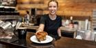 A barista serving a cake