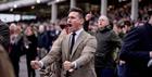 Cheltenham Festival men's style - male race goer dressed in suit in the grandstand