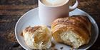 Croissant next to a cup of coffee