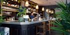 A bartender pouring a drink at the Brasserie Blanc Cheltenham bar