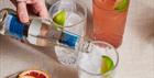 Three glasses of gin and tonic being poured