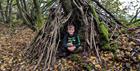 Boy in a den made from sticks