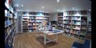 Inside Rossiter Books. Book cases and a white table stacked with books.