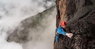 Leo Houlding, high up, climbing a sheer rock wall