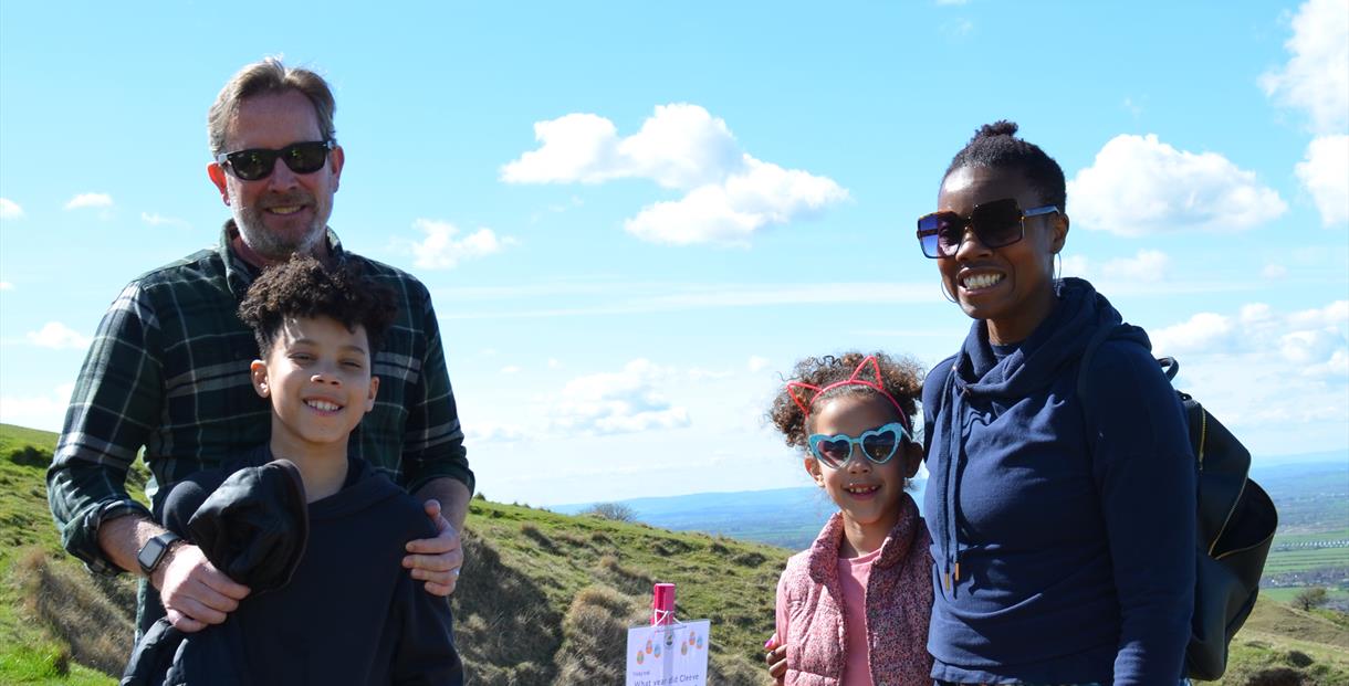 Family stood on Cleeve Common with an Easter trail sign
