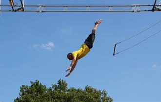 Image of someone executing a trick of a flying trapeze