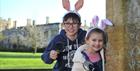 Children wearing bunny ears holding magnifying glasses