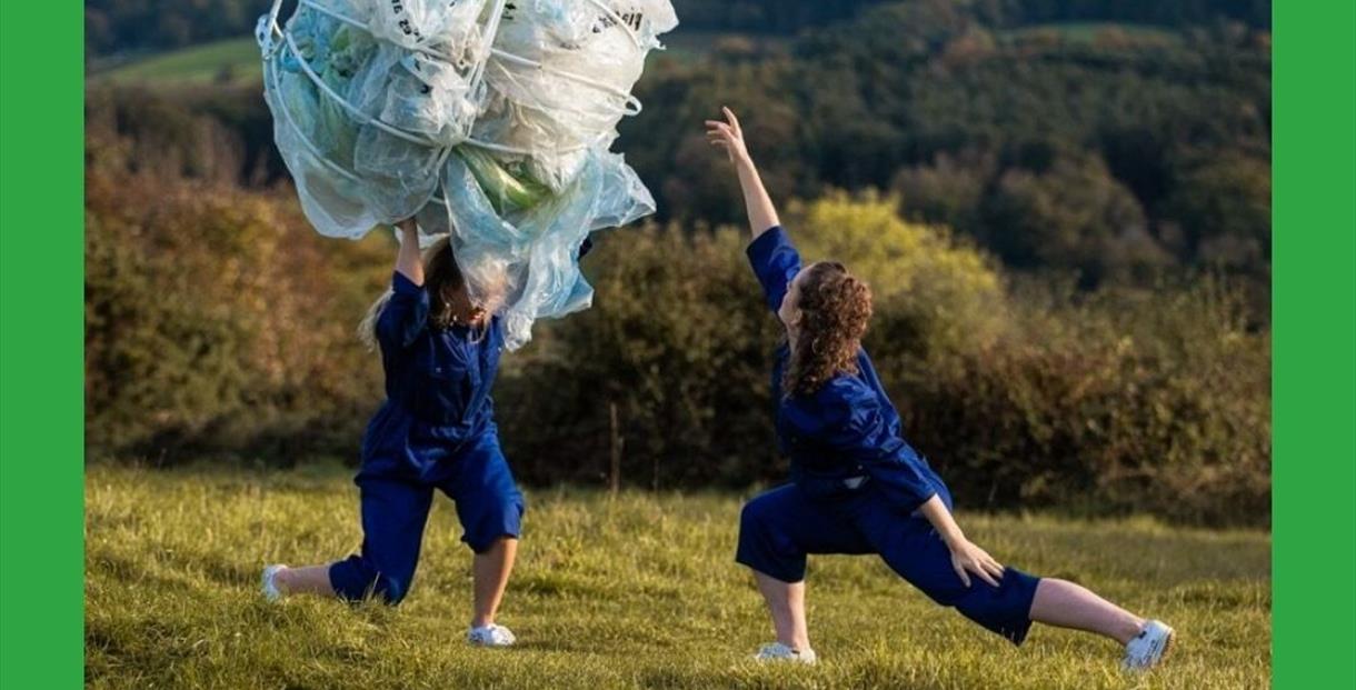 2 performers outside in a field combating plastic waste
