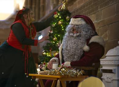 Santa and an elf putting up decorations