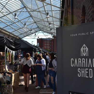 Customers at the Makers Market with the Carriage Shed sign