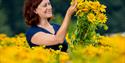 Woman enjoying a bouquet of yellow flowers
