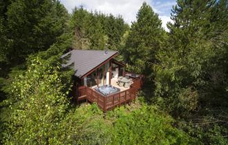 A cabin with a hot tub at Forest Holidays Delamere Forest