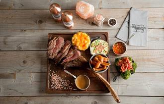 image of sliced tomahawk steak with sides
