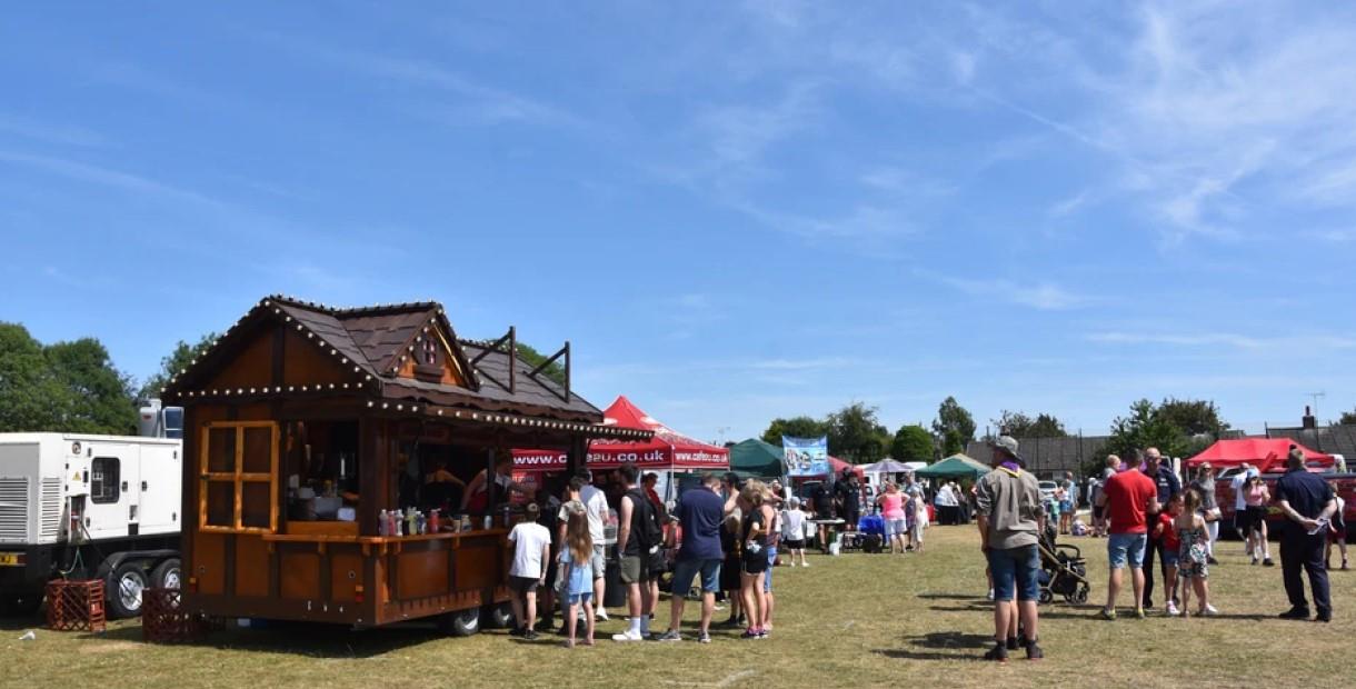 People queuing at stalls on a sunny day at Clowne Gala