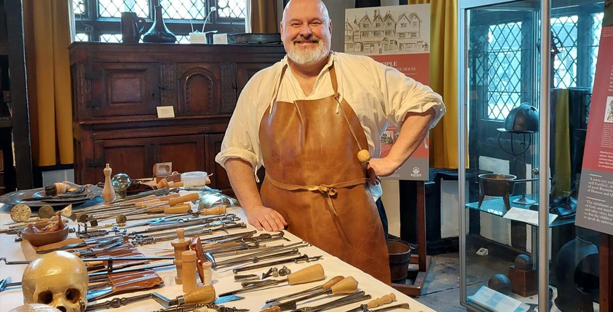 Tudor Surgeon with a table of surgical instruments