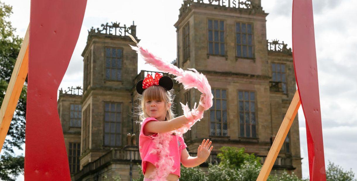 Young girl playing with a feather boa.