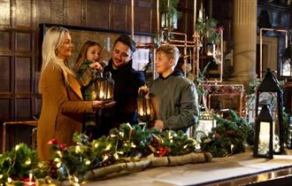 Family gathered around a Christmas tablescape with their lanterns at Hardwick.