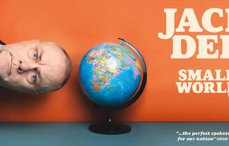 Jack Dee sideways next to a globe