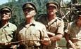 Alec Guiness as Colonel Nicholson with three other soldiers standing on the bridge