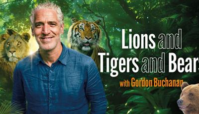 Gordon Buchanan standing in front of trees and a lion, tiger and bear