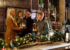 Family gathered around a Christmas tablescape with their lanterns at Hardwick.