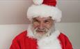 A close up image of Santa smiling.