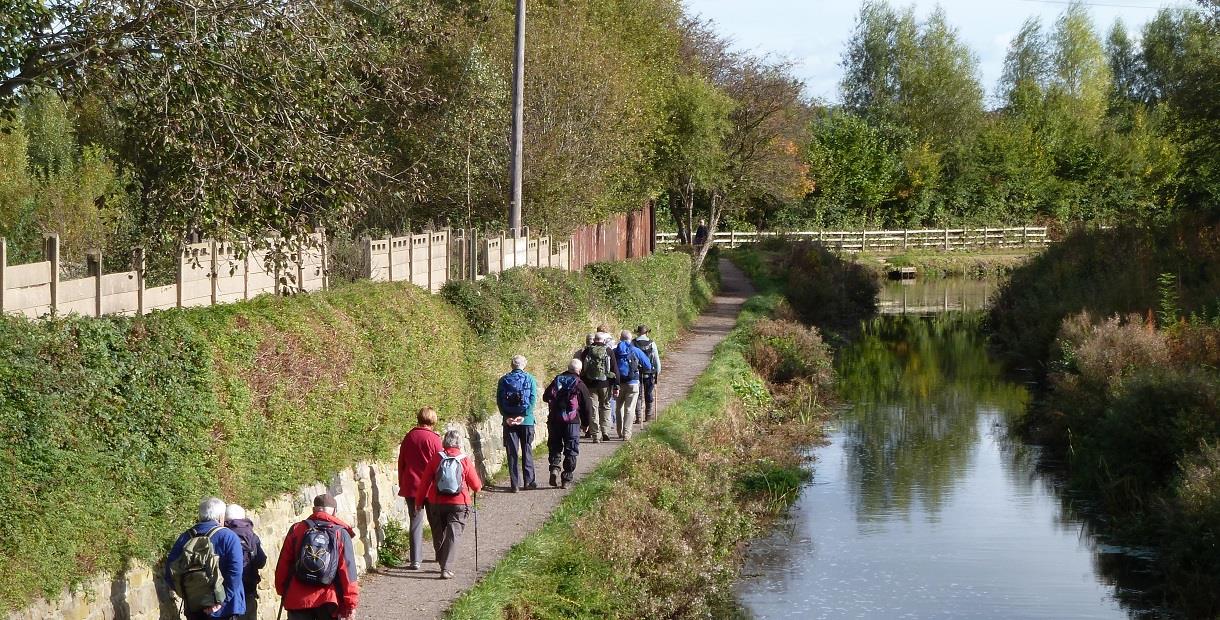 A group of people walking along the path next to Chesterfield Canal