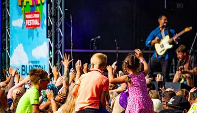 Children dancing to a singer on stage 
