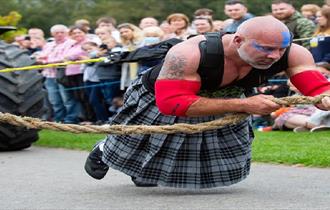 A man in a pulling a rope in a tug of war