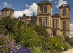 Hardwick Hall with purple flowers in front and blue skies