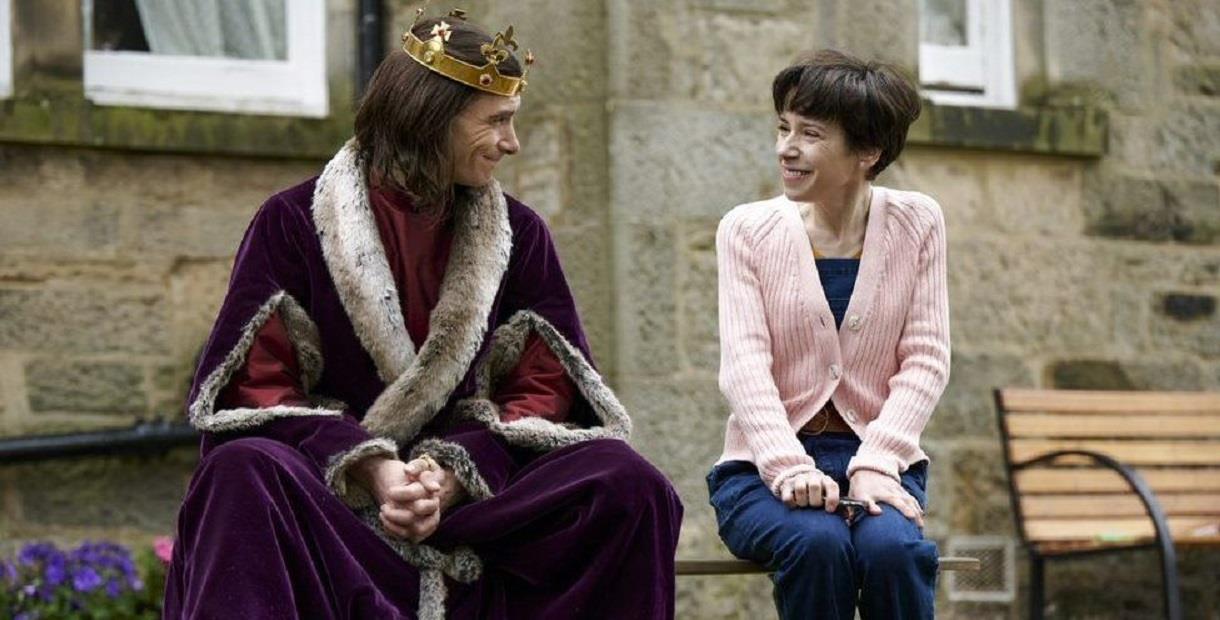 Sally Hawkins and Harry Lloyd sat on a bench in The Lost King