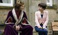 Sally Hawkins and Harry Lloyd sat on a bench in The Lost King