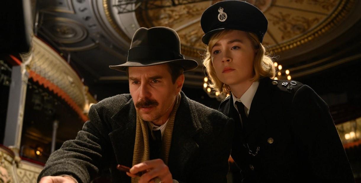 Sam Rockwell and Saoirse Ronan dressed in 1950s clothing inside a theatre