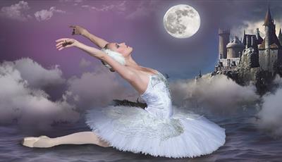 A single ballet dancer in the classic swan pose on what appears to be water, with a purple hued night sky behind her. There are atmospheric clouds aro