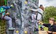 Two children on the climbing wall at Tapton Lock Festival