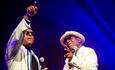 Chris Amoo and Dave Smith, in white jackets and sunglasses performing live