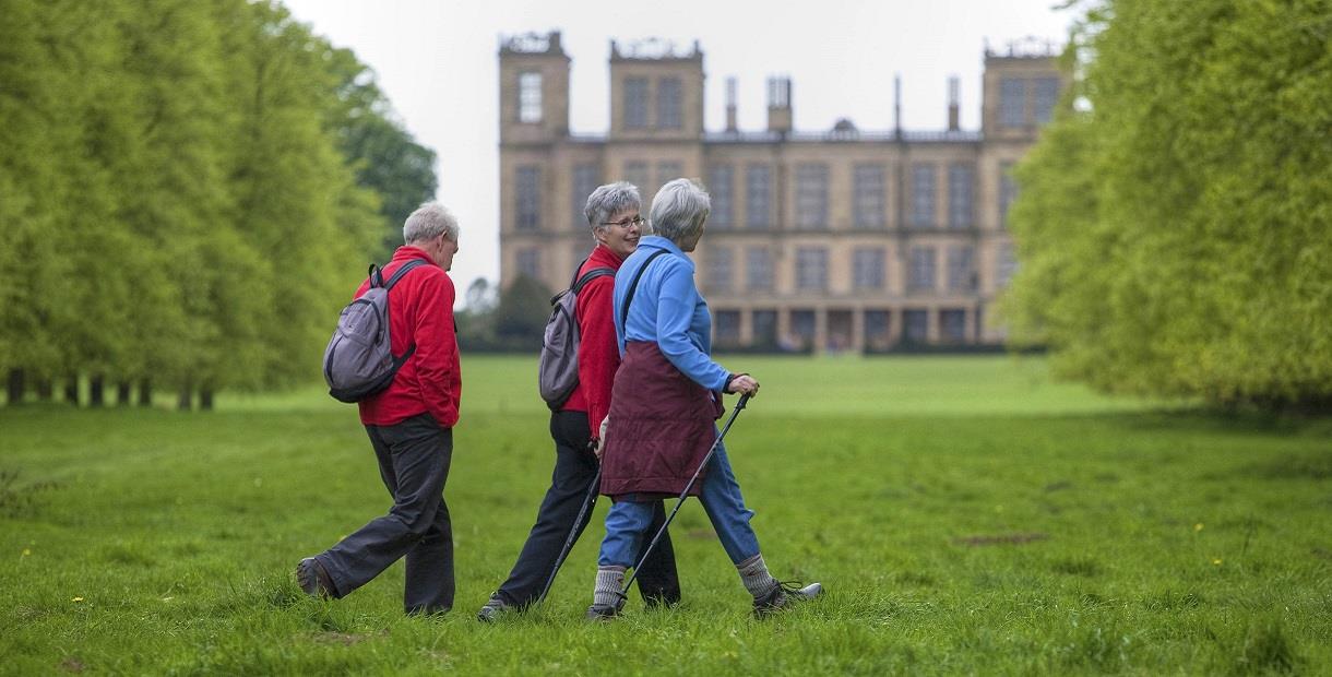 Three walkers with Hardwick Hall in the background