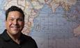 Dom Joly in front of a map of the world