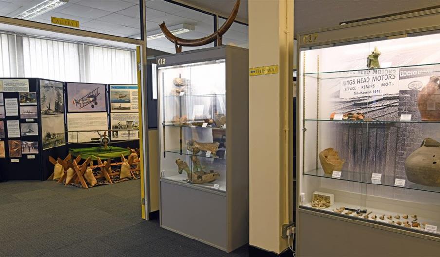 A museum gallery in Harwich Museum. A cabinet containing historic objects can be seen with information boards.
