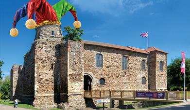 A picture of Colchester Castle with a Jester's hat superimposed on one of the towers