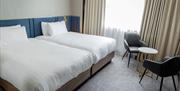 Twin beds at the Marks Tey Hotel with table and chair