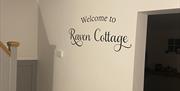 Raven Cottage sign on wall by staircase