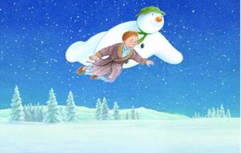 The Snowman and boy flying in the snowy sky